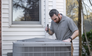HVAC technician inspecting an outdoor air conditioning unit