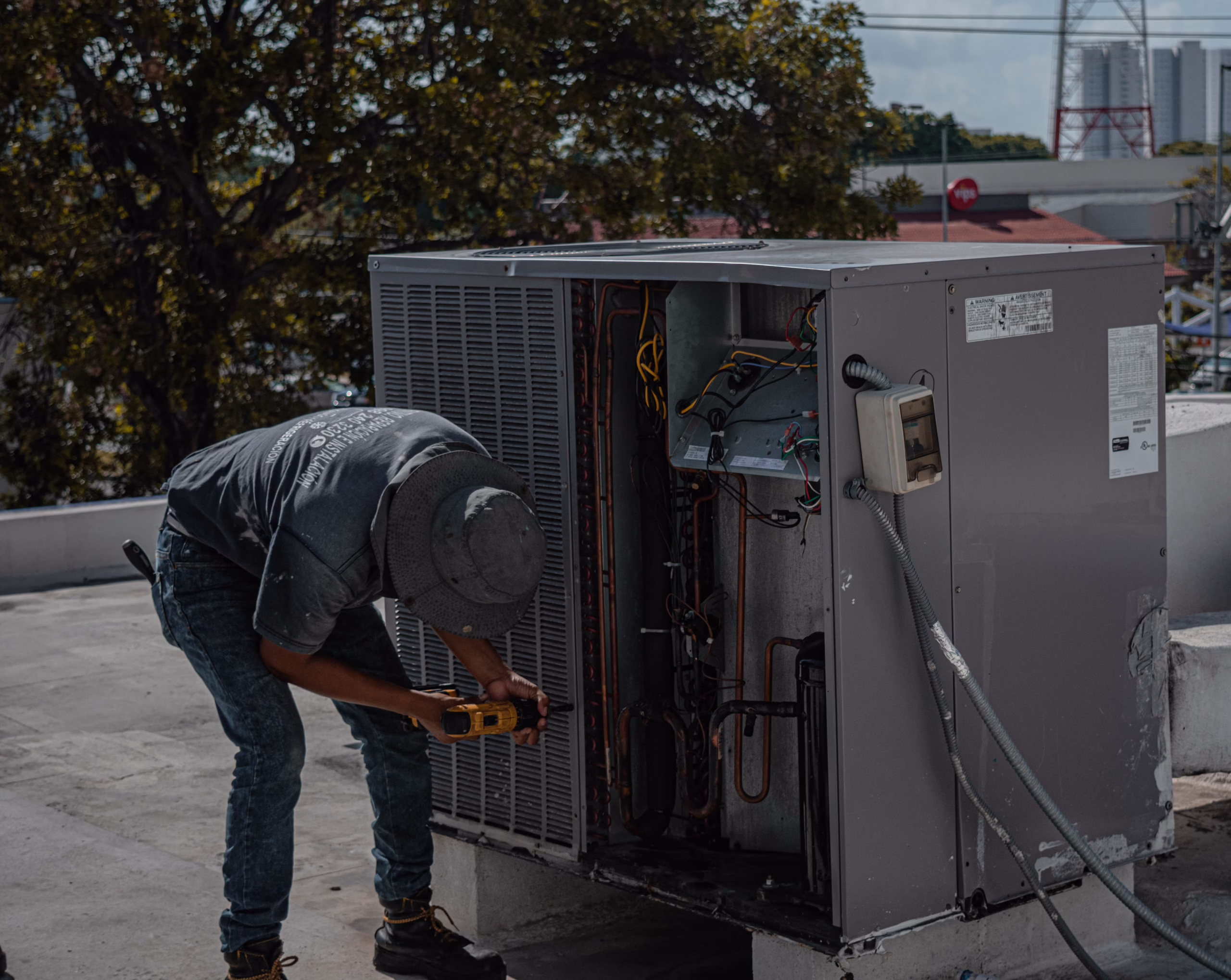 Technician servicing a rooftop HVAC unit